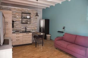 a living room with a purple couch and a kitchen at La Casetta in Quartu SantʼElena