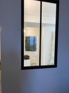 een spiegel aan een muur in een kamer bij Le Quai 7 3e in Dieppe