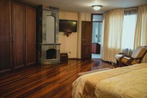 a bedroom with a fireplace and a bed and a television at Hotel Spa CASA REAL in Riobamba