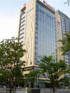 un grand bâtiment avec un panneau en haut dans l'établissement Ramada Plaza by Wyndham Gwangju, à Gwangju