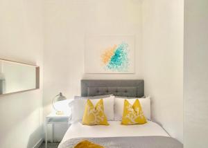 格拉斯哥的住宿－Hillington Central，白色卧室配有黄色枕头的床