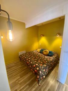 a bedroom with a bed in a yellow wall at Le Quai 7 3e in Dieppe