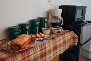 a table with a plate of bread and a coffee maker at Mickelson Trail Treehouse Suite in the heart of the beautiful Black Hills in Hill City