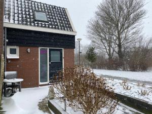 a brick house in the snow with a window at Appartement - B&B de Koog in Uitgeest
