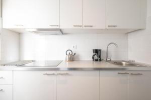 una cucina bianca con un lavello e un bollitore per il tè di Bubu Beach 4 a Los Cristianos