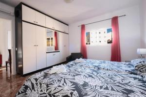 una camera da letto con un grande letto con una coperta blu e bianca di Bubu Beach 4 a Los Cristianos