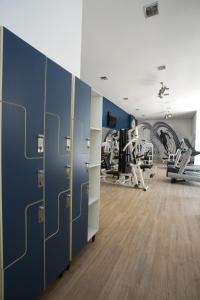 a gym with blue walls and wooden floors and machines at Locking's Santo Agostinho 10 in Belo Horizonte