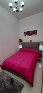 een groot bed met een rode sprei in een slaapkamer bij Gioiellino Salentino in Nardò