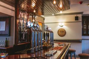 a bar in a pub with a counter and chairs at The Bulls Head in Milnthorpe