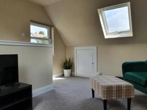 sala de estar con chimenea y sofá verde en Oakbank Cottage, en Pitlochry