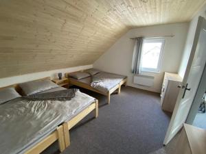 a room with two beds and a window at UBYTOVÁNÍ S WELLNESS in Dolní Dobrouč