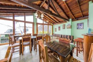 uma sala de jantar com mesas e cadeiras de madeira em Hotel El Bosque em Armênia