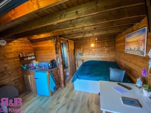 Chalet - B&B de Koog في Uitgeest: غرفة نوم في كابينة خشب بها سرير ومغسلة