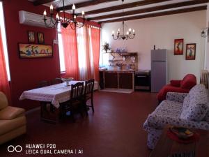 ein Wohnzimmer mit einem Tisch und einer Küche in der Unterkunft La casa di nicola in Trapani