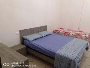 ein kleines Schlafzimmer mit einem Bett mit violetter Bettwäsche in der Unterkunft La casa di nicola in Trapani