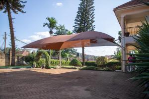 ein großer Regenschirm vor einem Haus in der Unterkunft Fred and Winnie BnB in Kampala