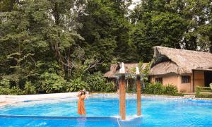 Hotel Maya Bell في بالينكو: امرأة تقف أمام حمام السباحة