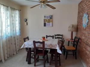 a dining room with a table and chairs and a ceiling fan at Cabaña Namasté in Huerta Grande