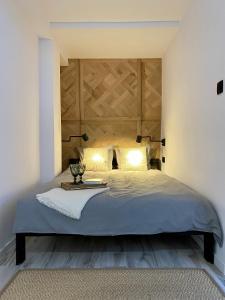 Schlafzimmer mit einem großen Bett mit einem Kopfteil aus Holz in der Unterkunft TURBOT apartament in Gdynia