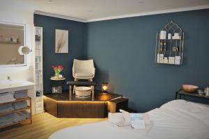 a bedroom with a bed and a chair and a sink at Hotel Alter Muschelsaal in Büsum