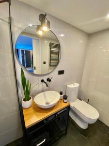 ein Badezimmer mit einem Waschbecken, einem WC und einem Spiegel in der Unterkunft TURBOT apartament in Gdynia