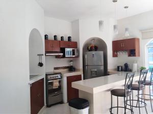 a kitchen with a refrigerator and some chairs in it at Serenity Home Hospedaje con confort y seguridad in Mérida