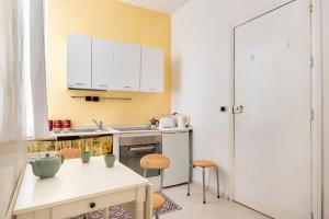 a kitchen with white cabinets and a table and chairs at Casa Clara Appartamenti - Danzettino in Perugia
