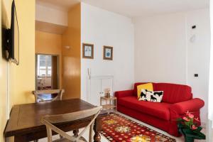 a living room with a red couch and a table at Casa Clara Appartamenti - Danzettino in Perugia