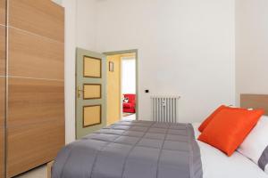 a bedroom with a bed with an orange pillow at Casa Clara Appartamenti - Danzettino in Perugia