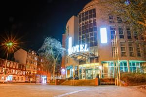 un edificio con una señal de neón en el costado. en Hotel Kiel by Golden Tulip, en Kiel