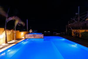 una piscina por la noche con luces azules en Pousada Oásis Galinhos - Experiências Únicas para Pessoas Únicas, en Galinhos