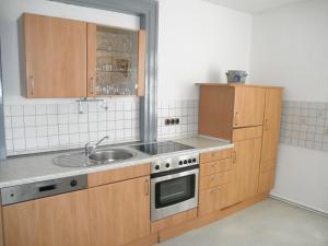 eine Küche mit Holzschränken und einem Waschbecken in der Unterkunft Altstadthaus in Arnsberg