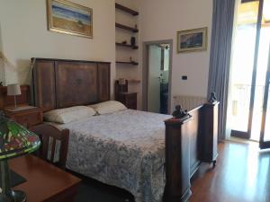 a bedroom with a bed with a wooden head board at Appartamento Teocle beach in Giardini Naxos
