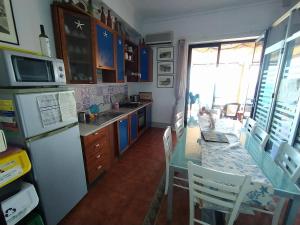 a kitchen with a refrigerator and a table with chairs at Appartamento Teocle beach in Giardini Naxos
