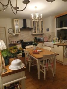 Judy's B&B private home في كارديف: مطبخ مع طاولة خشبية مع كراسي وغرفة طعام
