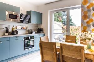 a kitchen with blue cabinets and a wooden table at Haus Josef in St. Andrä am Zicksee