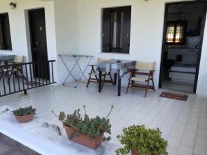 a patio with a table and chairs and plants at Olga Paltsi Rooms in Paltsi Pilion
