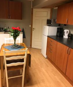 a kitchen with a table with a vase of flowers on it at Taras Rom og leiligheter in Kragerø