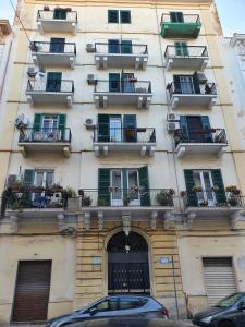 a building with balconies and cars parked in front of it at Regina Elena Apartments in Taranto