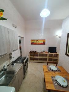 a kitchen with a sink and a stove and a table at Regina Elena Apartments in Taranto
