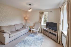 a living room with a couch and a television at Host & Stay - 57 Woodland View in Holmfirth