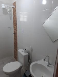 uma casa de banho branca com um WC e um lavatório em Pousada Portal do Cabo em João Pessoa