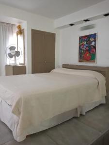 1 cama blanca grande en un dormitorio blanco en Complejo Casa Clara en Santa Clara del Mar