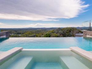 a swimming pool with a view of the mountains at Beach View At One Mile 8 infinity complex pool and WI FI in Anna Bay