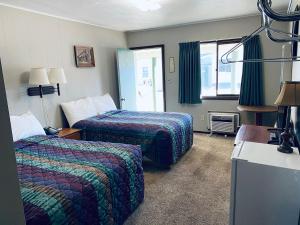 ein Hotelzimmer mit zwei Betten und einem Fenster in der Unterkunft Wigwam Motel in Cody