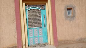 a blue door with a window on a building at Chez zakaria guest house in Merzouga