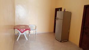 a kitchen with a refrigerator and a table and chairs at Chez zakaria guest house in Merzouga