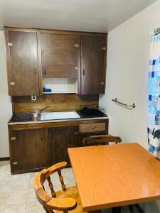 eine Küche mit Holzschränken und einem Holztisch mit Stühlen in der Unterkunft Wigwam Motel in Cody