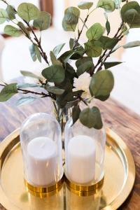 un piatto d'oro con due candele e un vaso con fiori di La Nogalera Torremolinos Centro a Torremolinos