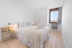 biała sypialnia z łóżkiem i oknem w obiekcie La Nogalera Torremolinos Centro w mieście Torremolinos